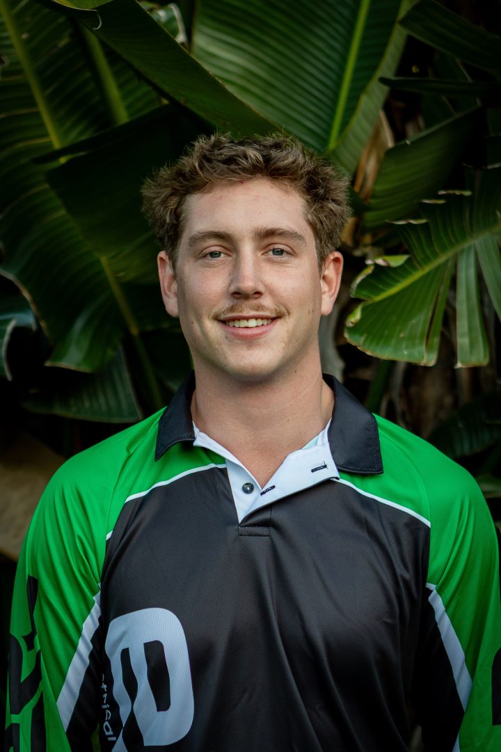 Smiling man in green shirt, tropical background