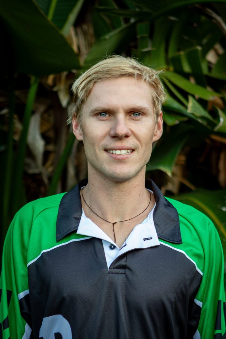 Blonde person in green sports shirt outdoors.